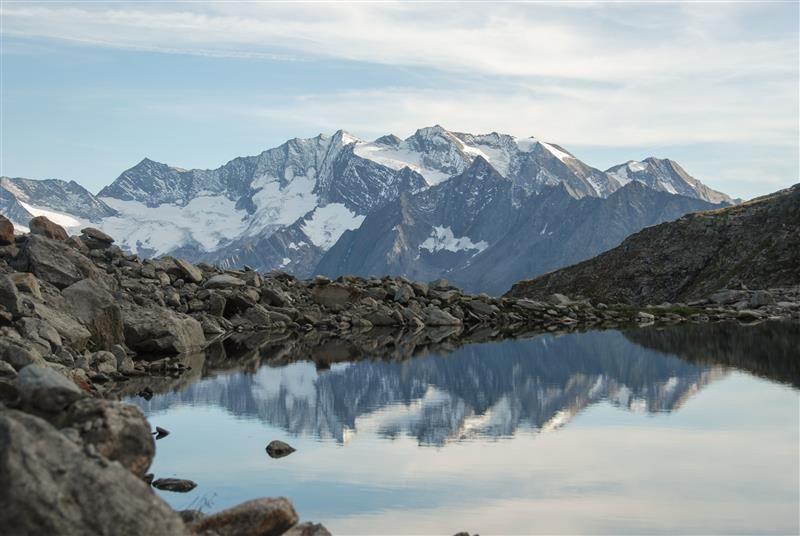 Alpinsee mit verschneitem Bergpanorama im Hintergrund