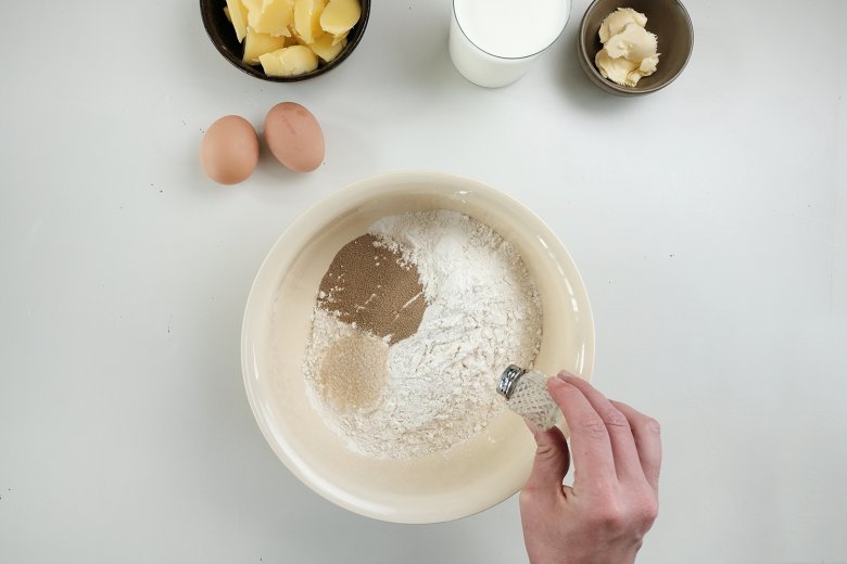 Germ, Salz und Zucker mit dem Mehl in eine Germteigschüssel geben und gut durchmischen.