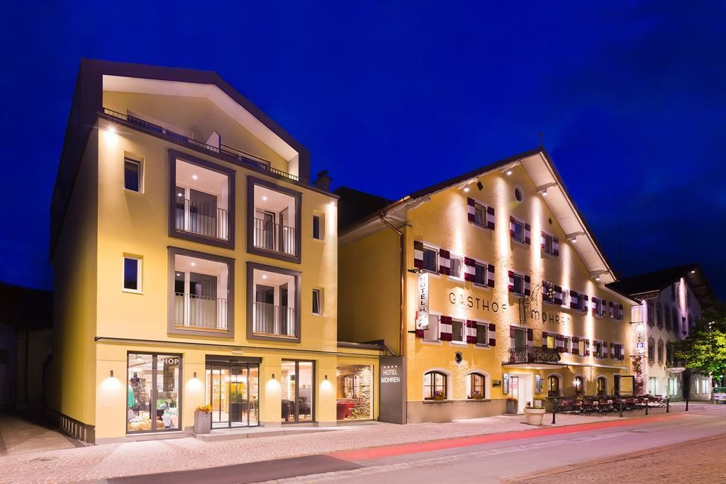Ein modernes Hotelgebäude mit einer hellen Fassade. Die Szene zeigt die äußere Sicht bei Nacht mit beleuchteten Fenstern.
