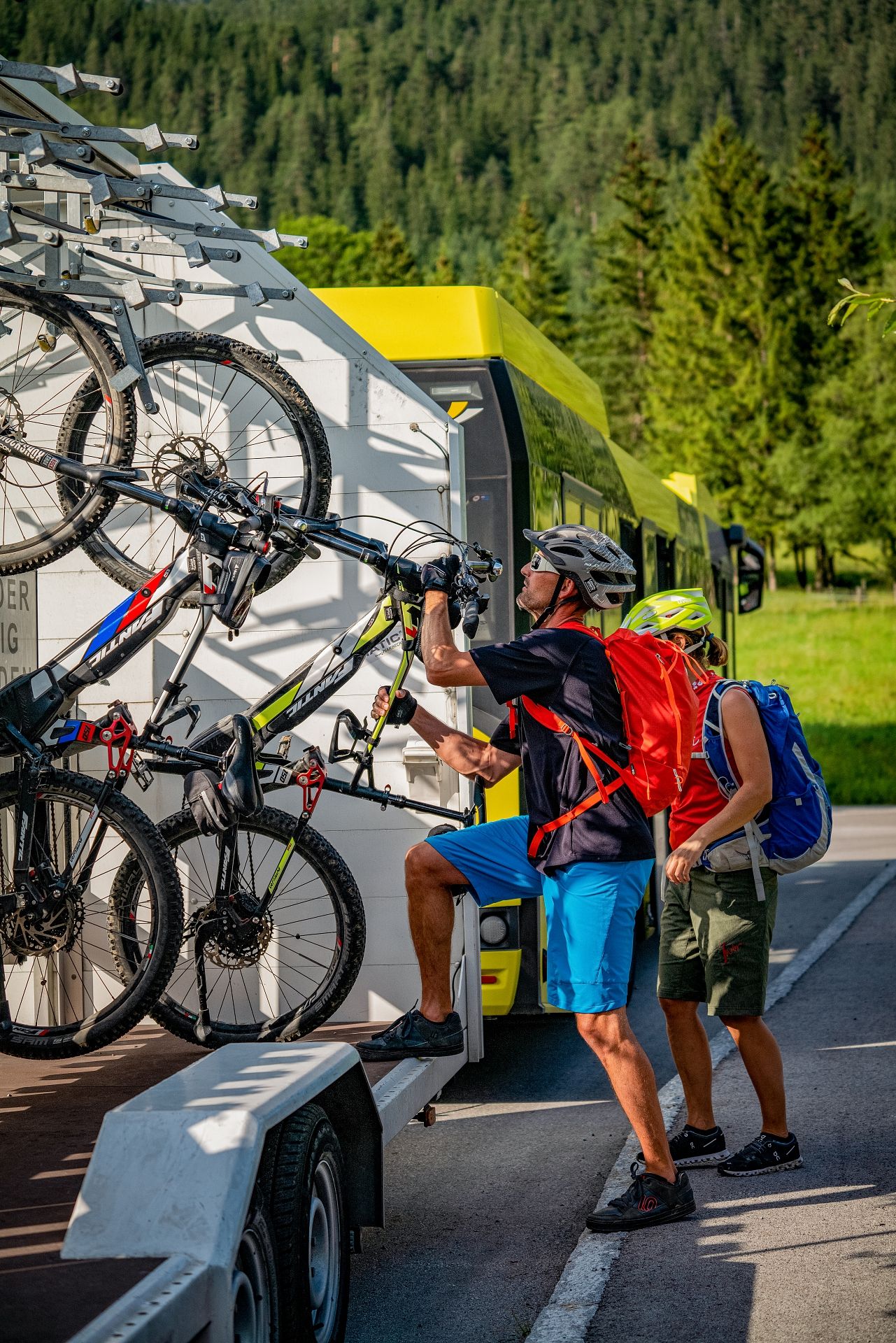 Menschen steigen in Linienbus mit Fahrradanhänger