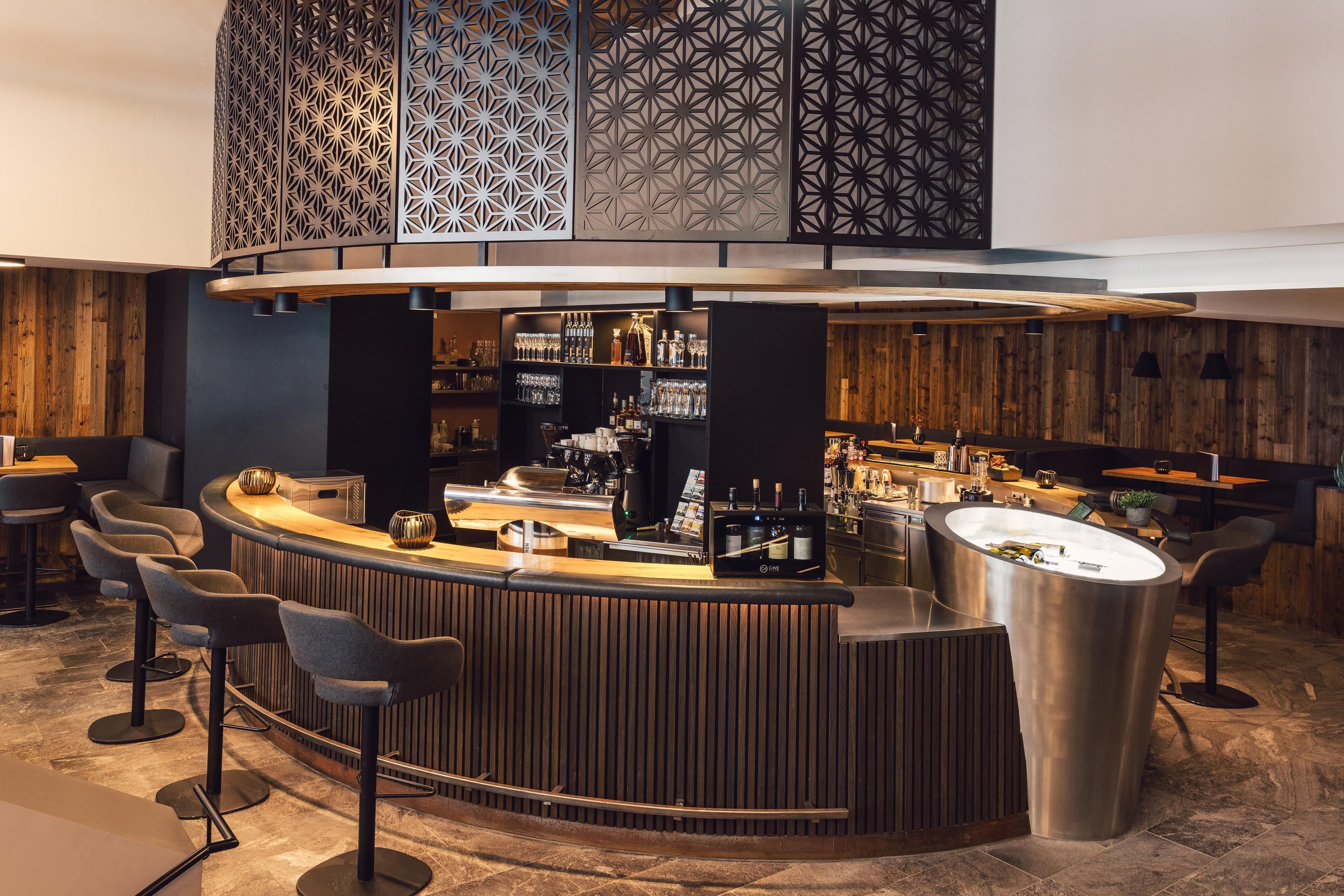 Eine moderne Bar mit einem eleganten Design und Holzdekor. Die Bar bietet eine angenehme Atmosphäre zum Entspannen.