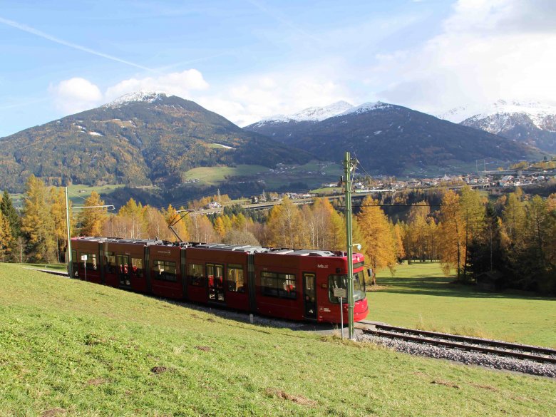 Idyllische Fahrt von Innsbruck nach Fulpmes im Stubaital: Hier tuckert die Straßenbahn über die Telfer Wiesen. Im Hintergrund sieht man den schneebedeckten Patscherkofel. (Foto: Haisjackl)