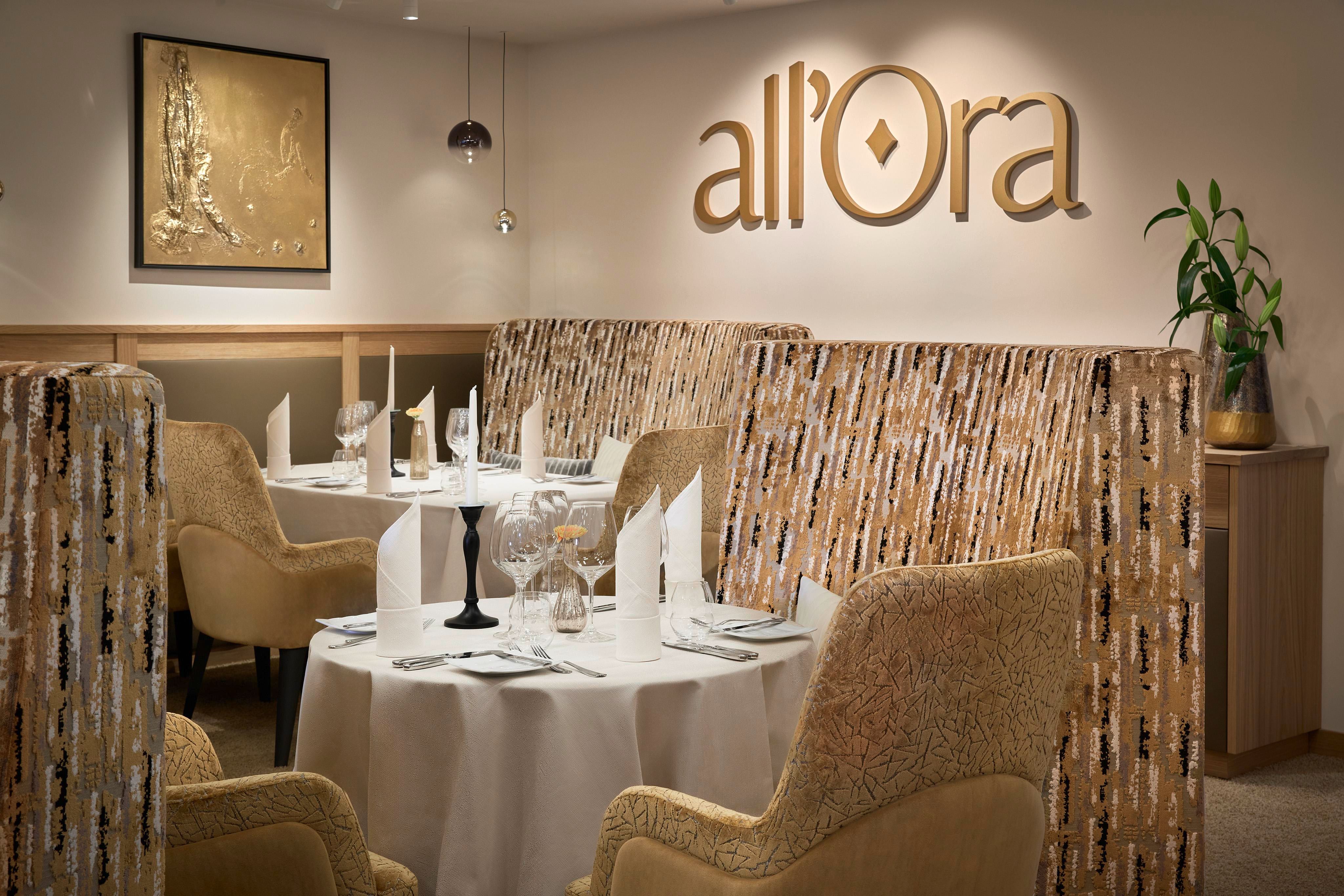 Ein elegantes Restaurant mit modernen Essbereichen und stilvollen Möbeln. Die Tische sind elegant dekoriert und es gibt Pflanzen zur Verschönerung des Ambientes.
