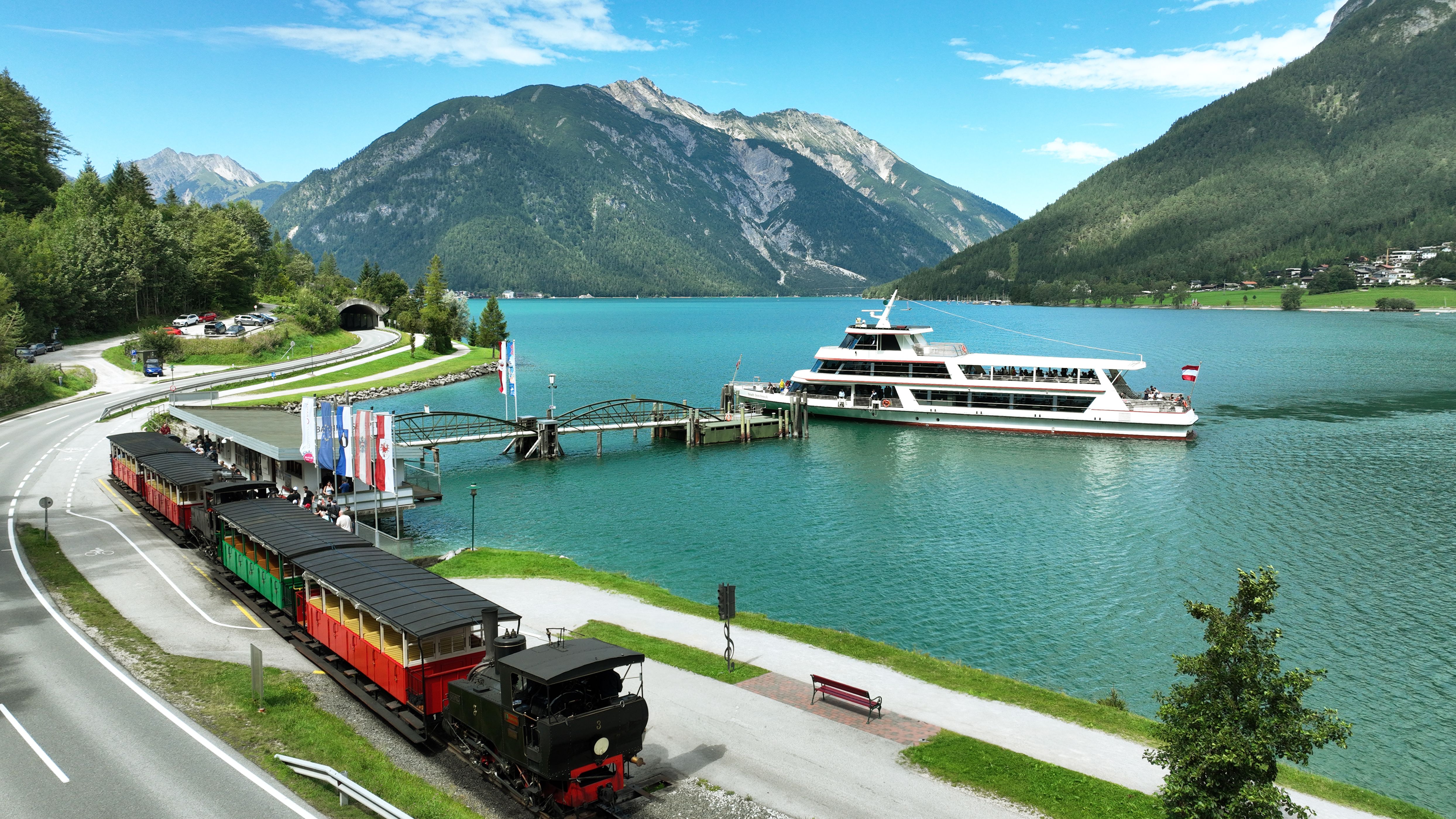 Achenseebahn hält direkt am Achensee, Schiff der Achenseeschifffahrt auf dem Achensee