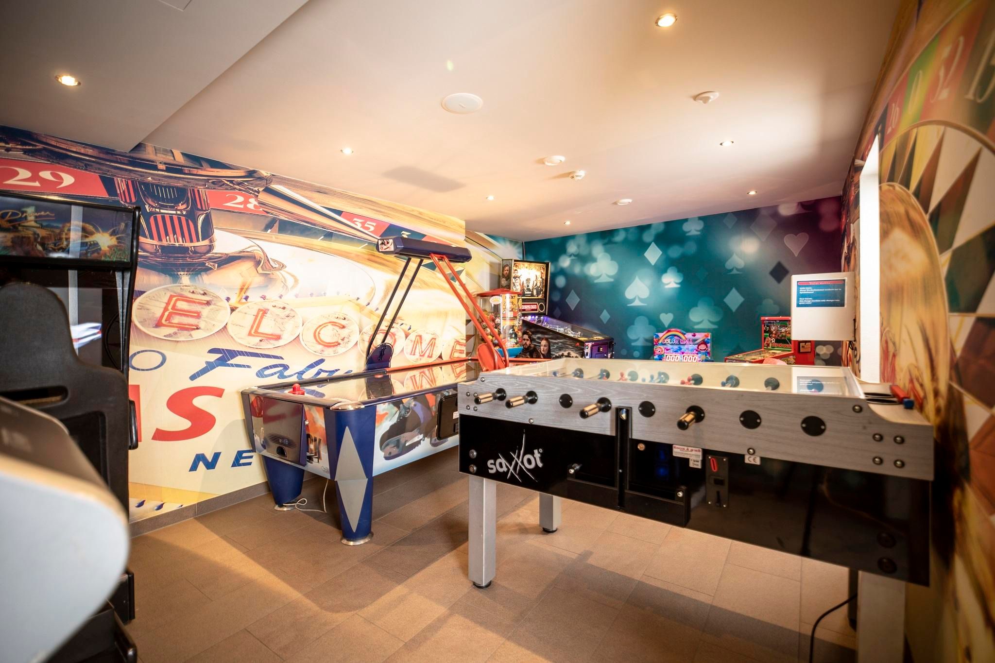 Ein unterhaltsamer Spielraum mit Air-Hockey-Tisch und Tischfußball. Bunte Wände und verschiedene Spielmöglichkeiten sorgen für Spaß und Freude.