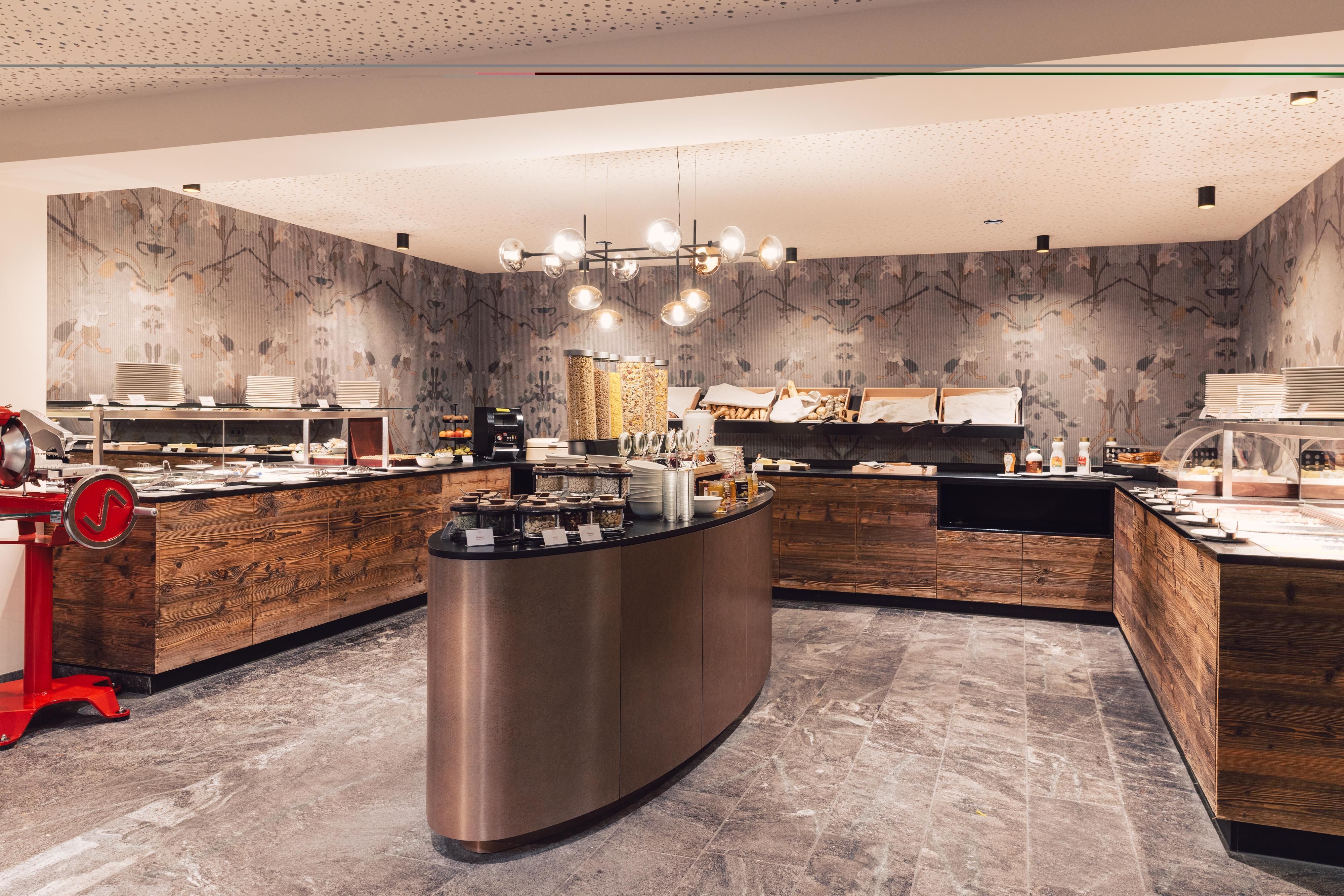 Ein modernes Bistro mit Holzregalen und einer Vielzahl von Speisen. Die Wände sind geschmackvoll dekoriert und die Beleuchtung schafft eine einladende Atmosphäre.