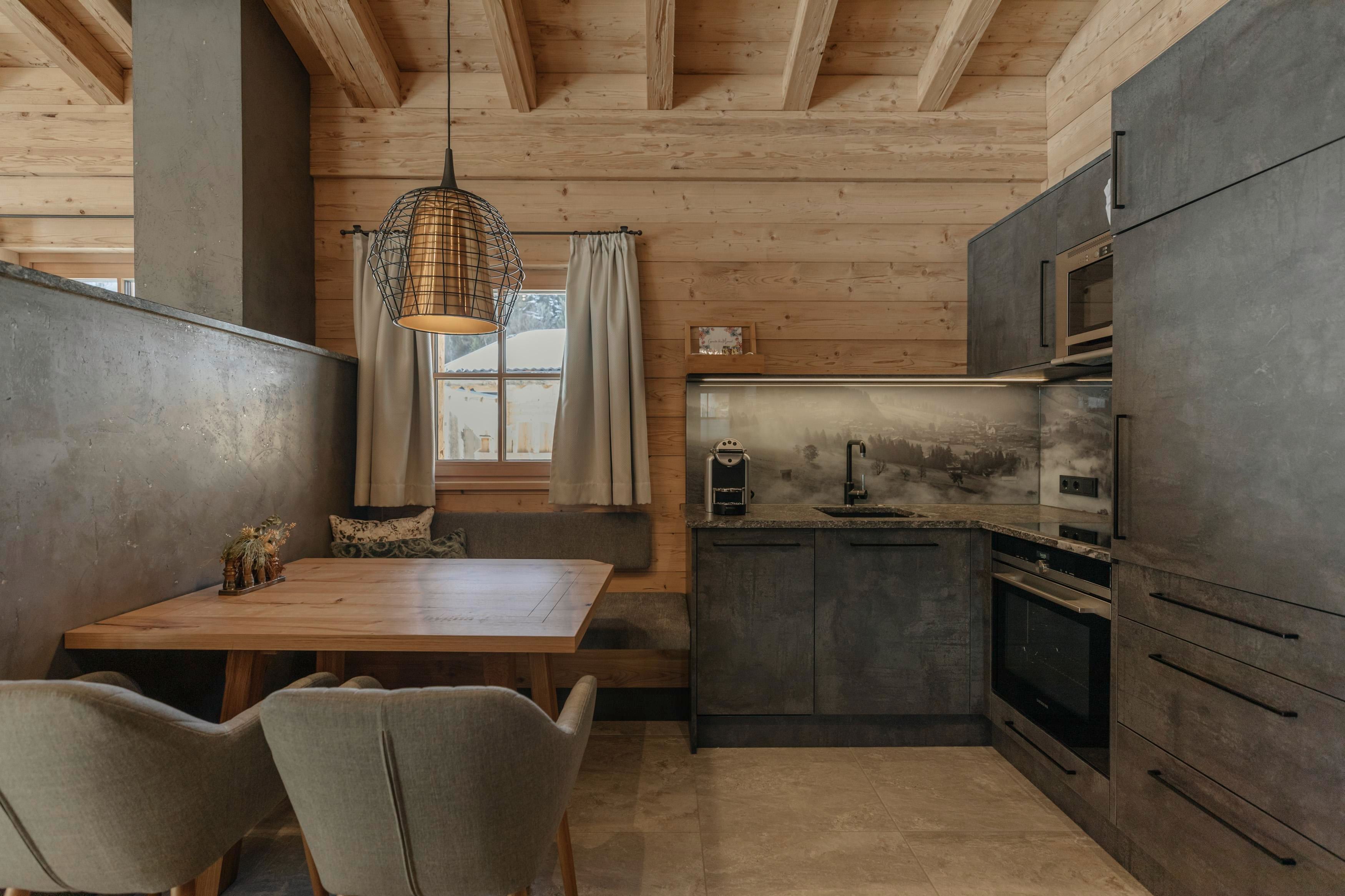 Eine moderne Küche mit Holzverkleidung und gemütlichem Essbereich. Die Einrichtung ist funktional und stilvoll, ideal für gesellige Zusammenkünfte.
