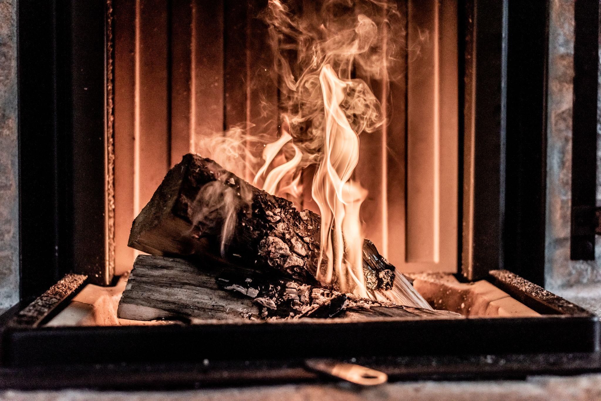 Ein knisterndes Feuer im Kamin mit lodernden Flammen. Die Atmosphäre ist warm und gemütlich.