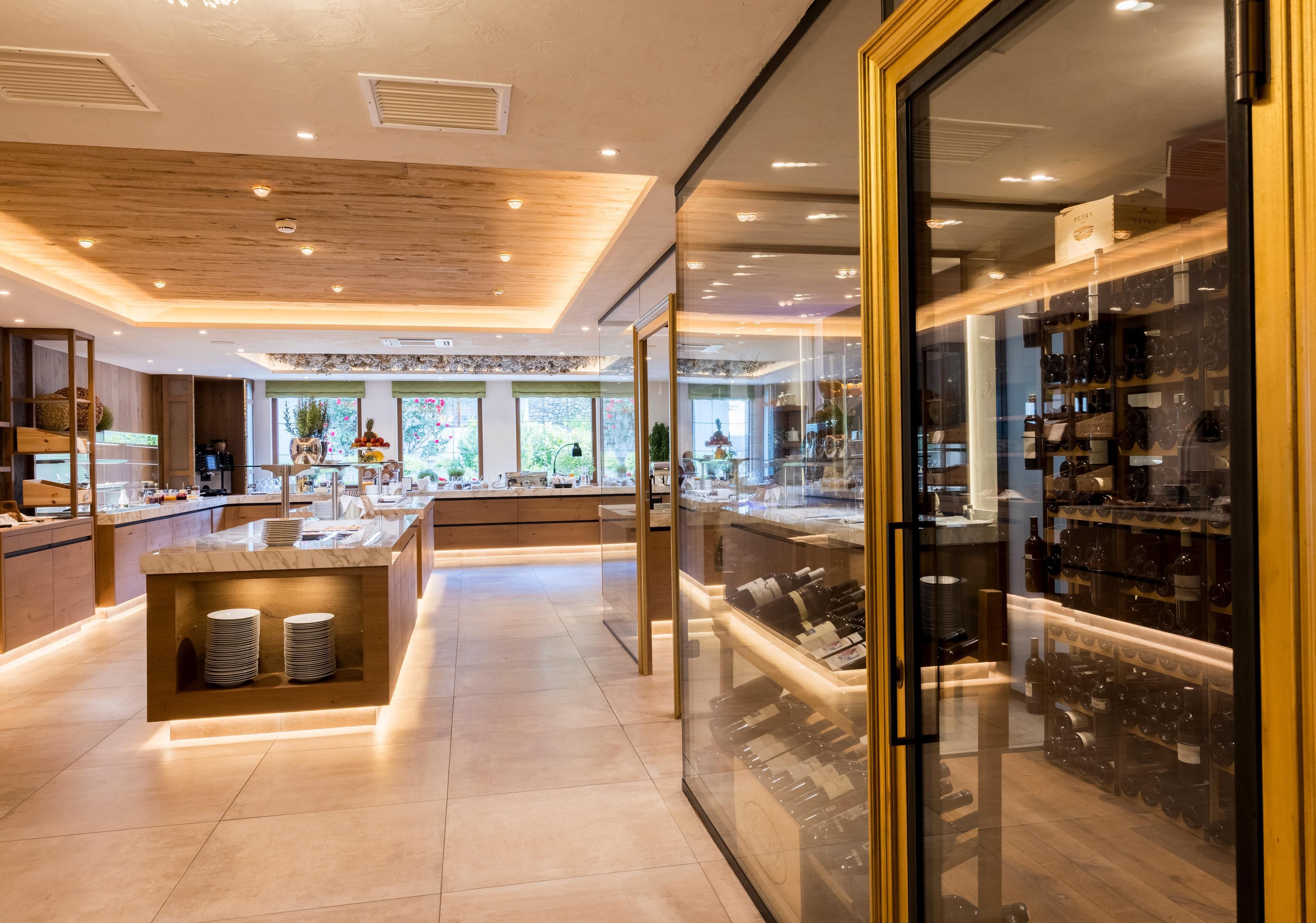 Ein stilvoller Buffetbereich mit einer modernen Einrichtung. Die beleuchteten Regale zeigen eine Auswahl an Speisen und Getränken.