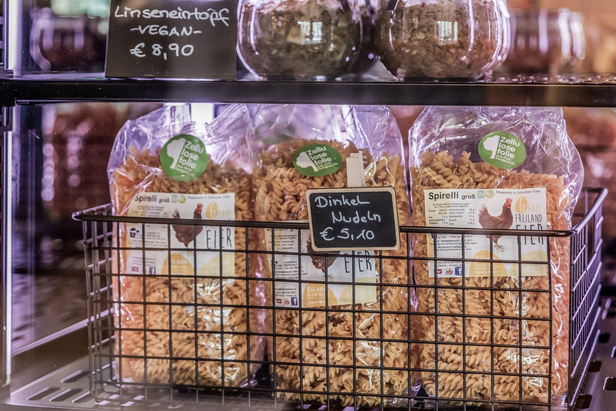 Eine Auslage mit Dinkel-Nudeln in einem Korb. Die Nudeln sind biologisch und in ansprechenden Verpackungen präsentiert.
