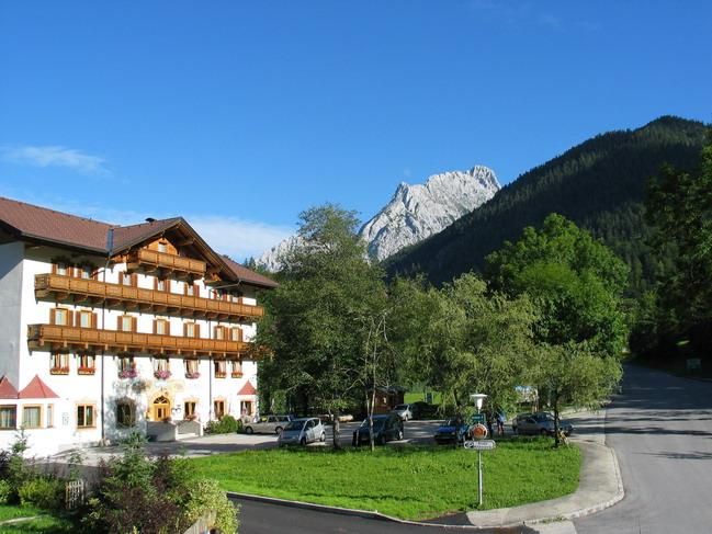 Ein charmantes Hotel in einer malerischen Berglandschaft. Die Umgebung ist grün und von majestätischen Bergen umgeben.