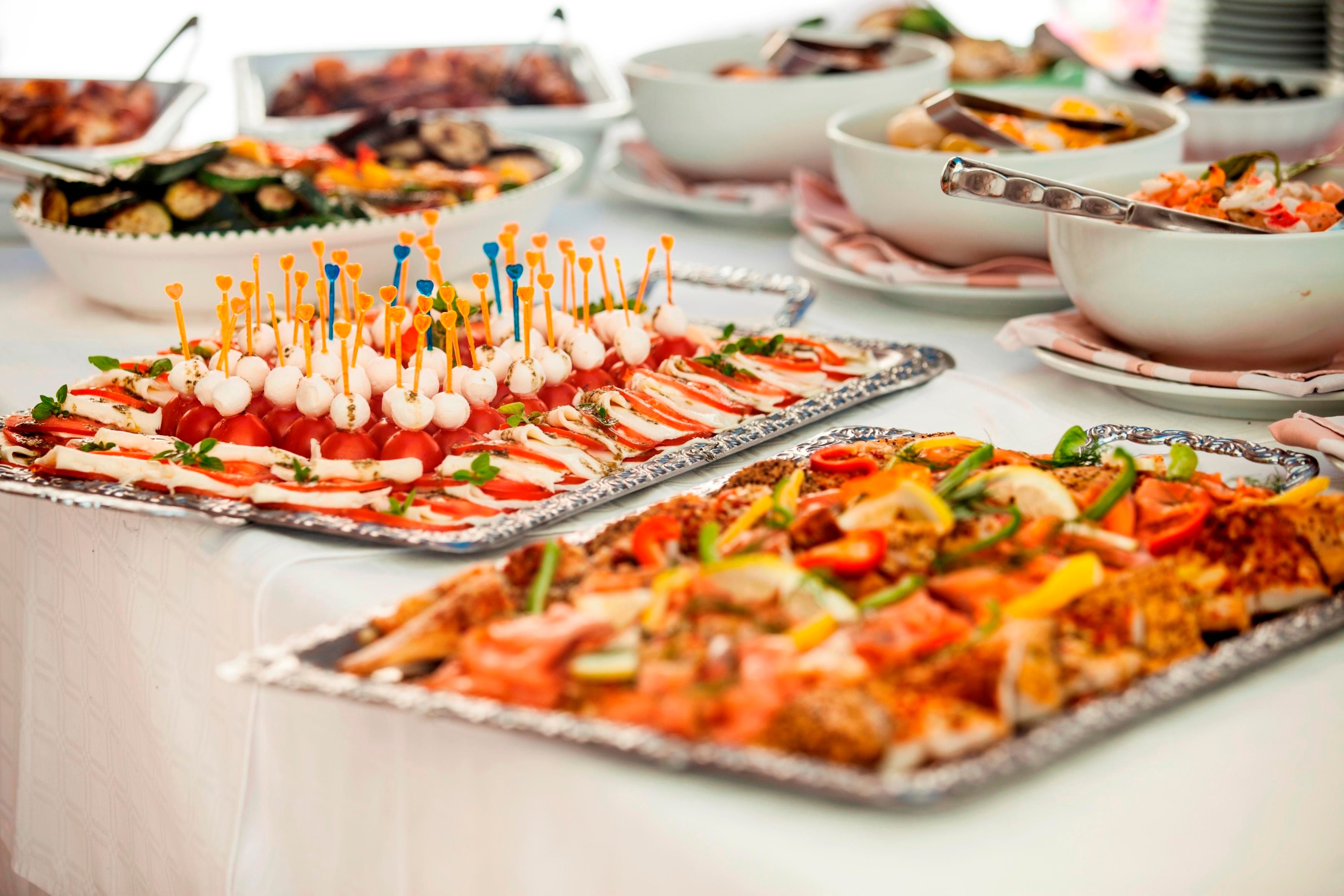 Ein schön angerichtetes Buffet mit verschiedenen Vorspeisen. Farbenfrohe Platten mit frischem Gemüse und leckeren Häppchen laden zum Probieren ein.