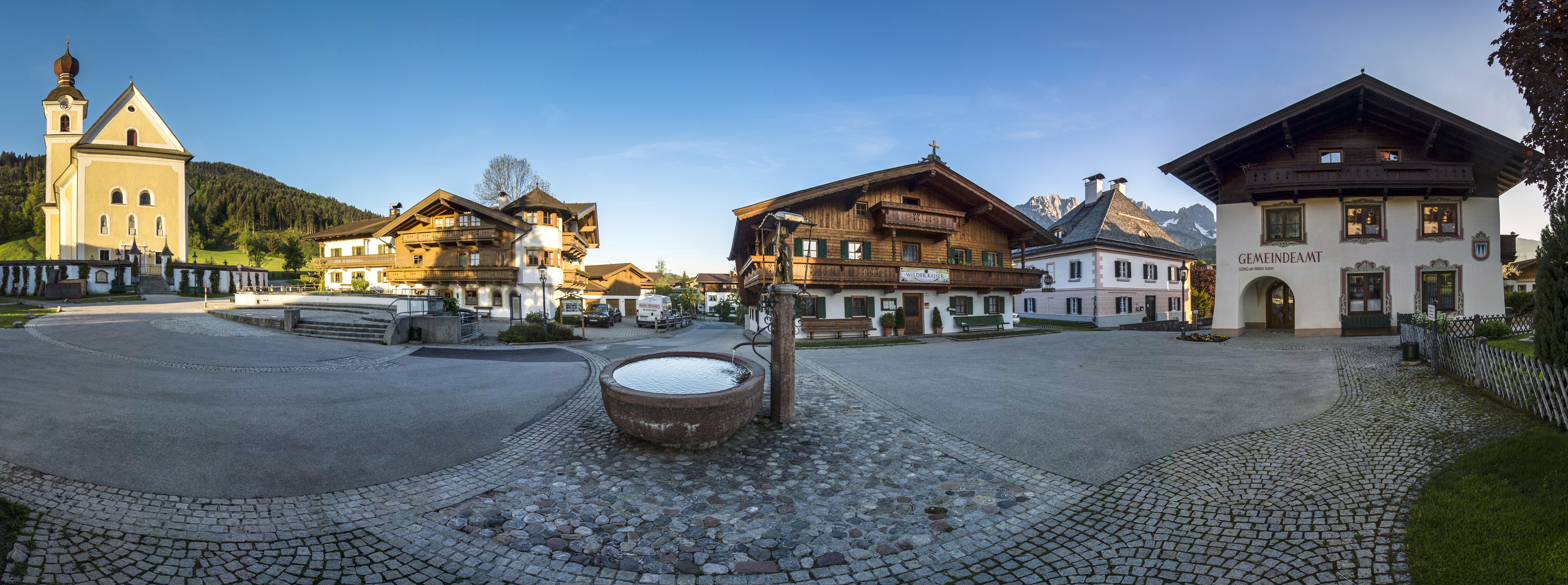 Dorfplatz vom Ort Going mit Kirche, Brunnen und Gasthaus