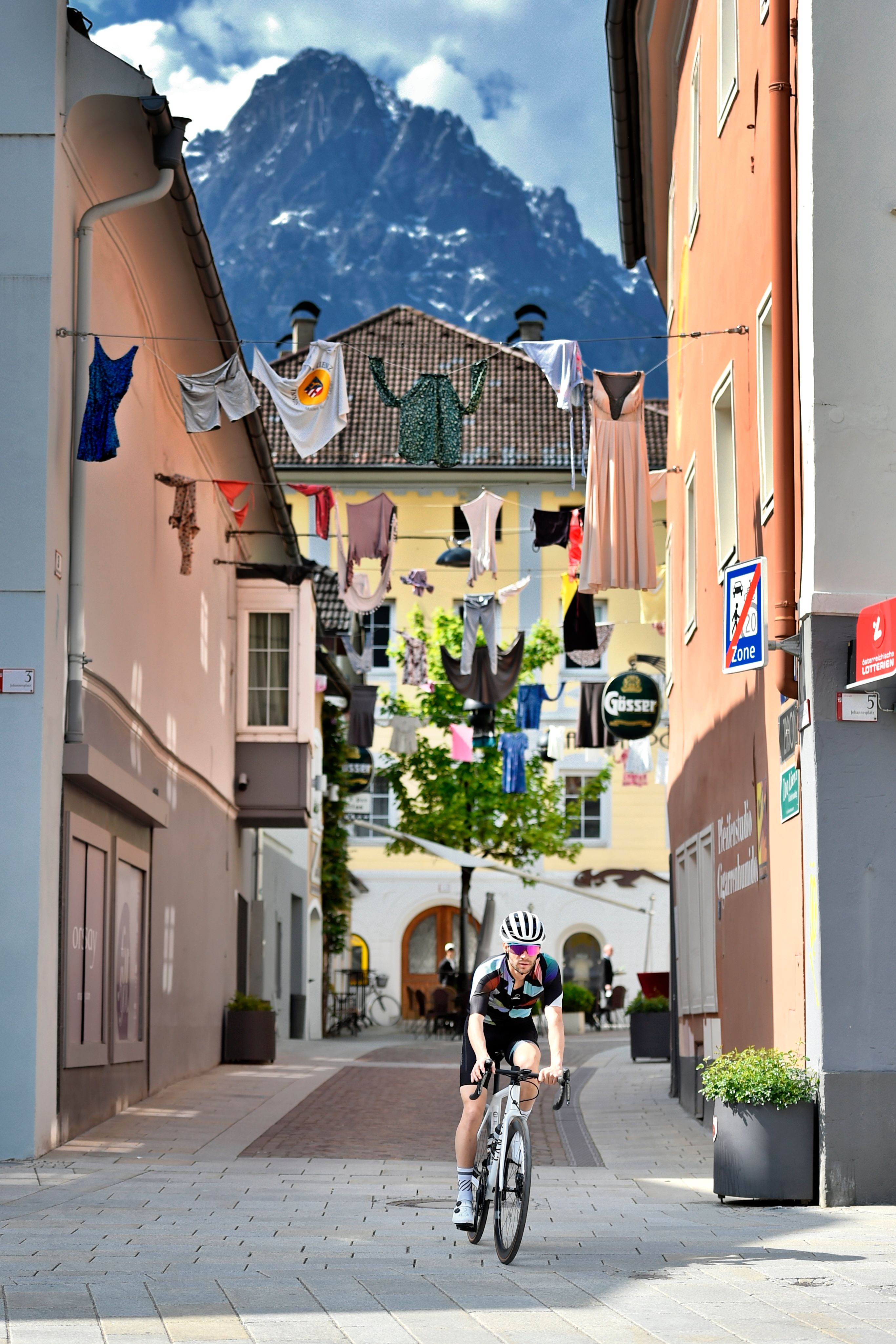 Rennradfahren in der Innenstadt von Lienz, Trikots hängen in den Straßen