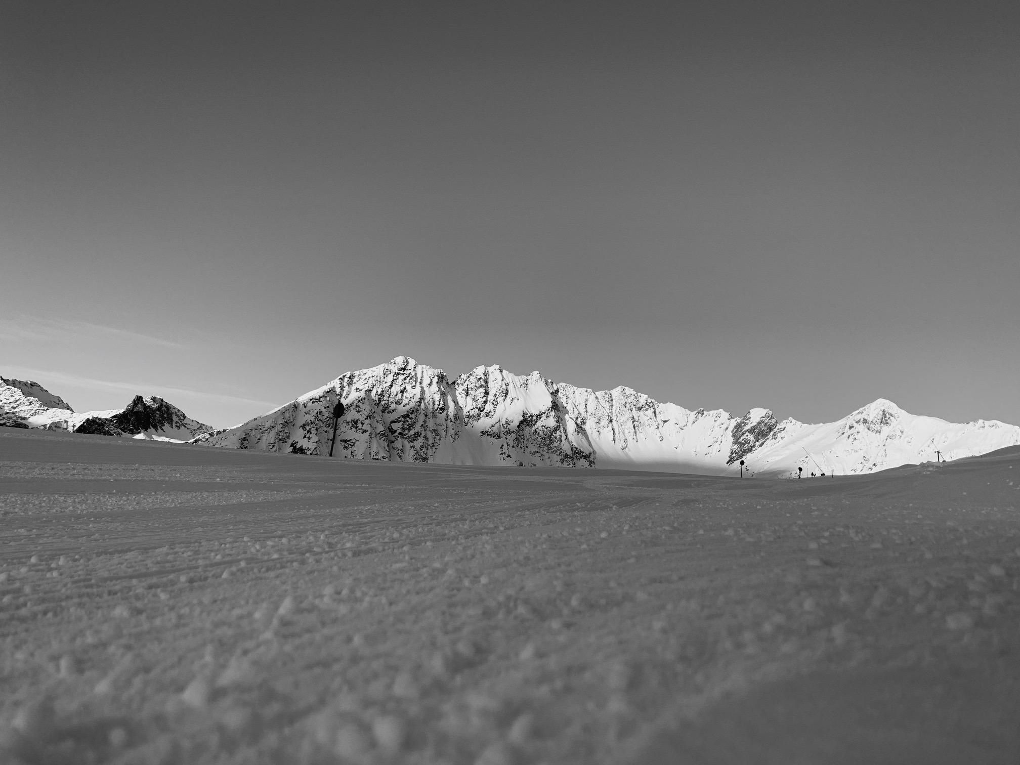 Eine beeindruckende Winterlandschaft mit schneebedeckten Bergen. Der Himmel ist klar und die Atmosphäre ist friedlich.