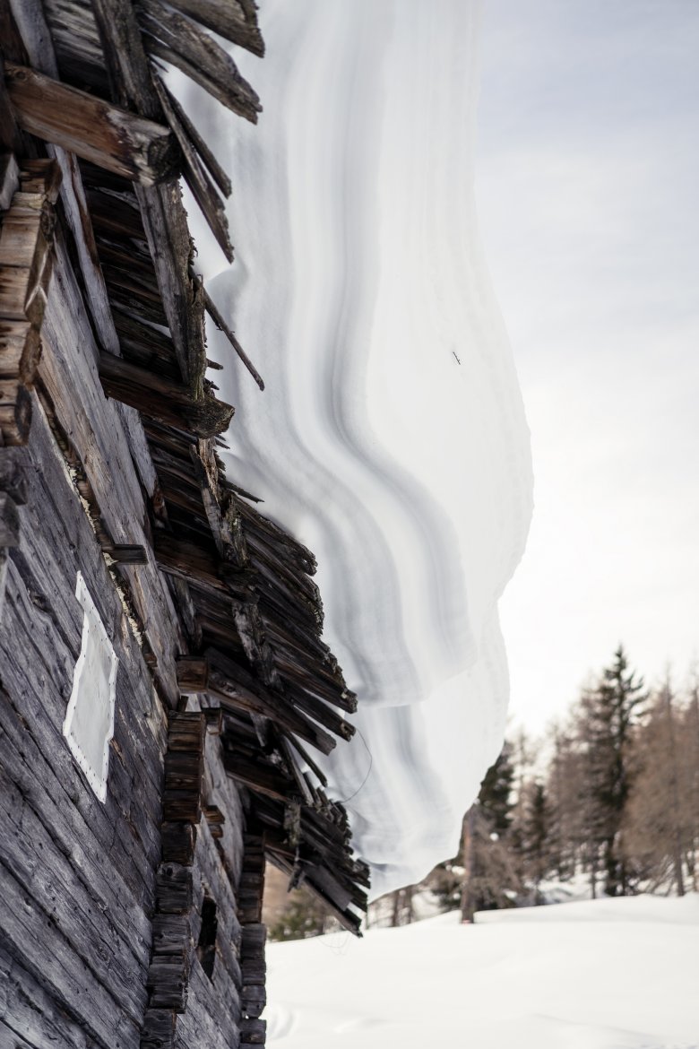             Zuckerguss: Wie eine Tortenschicht liegt der Schnee auf einem Hüttendach.

          