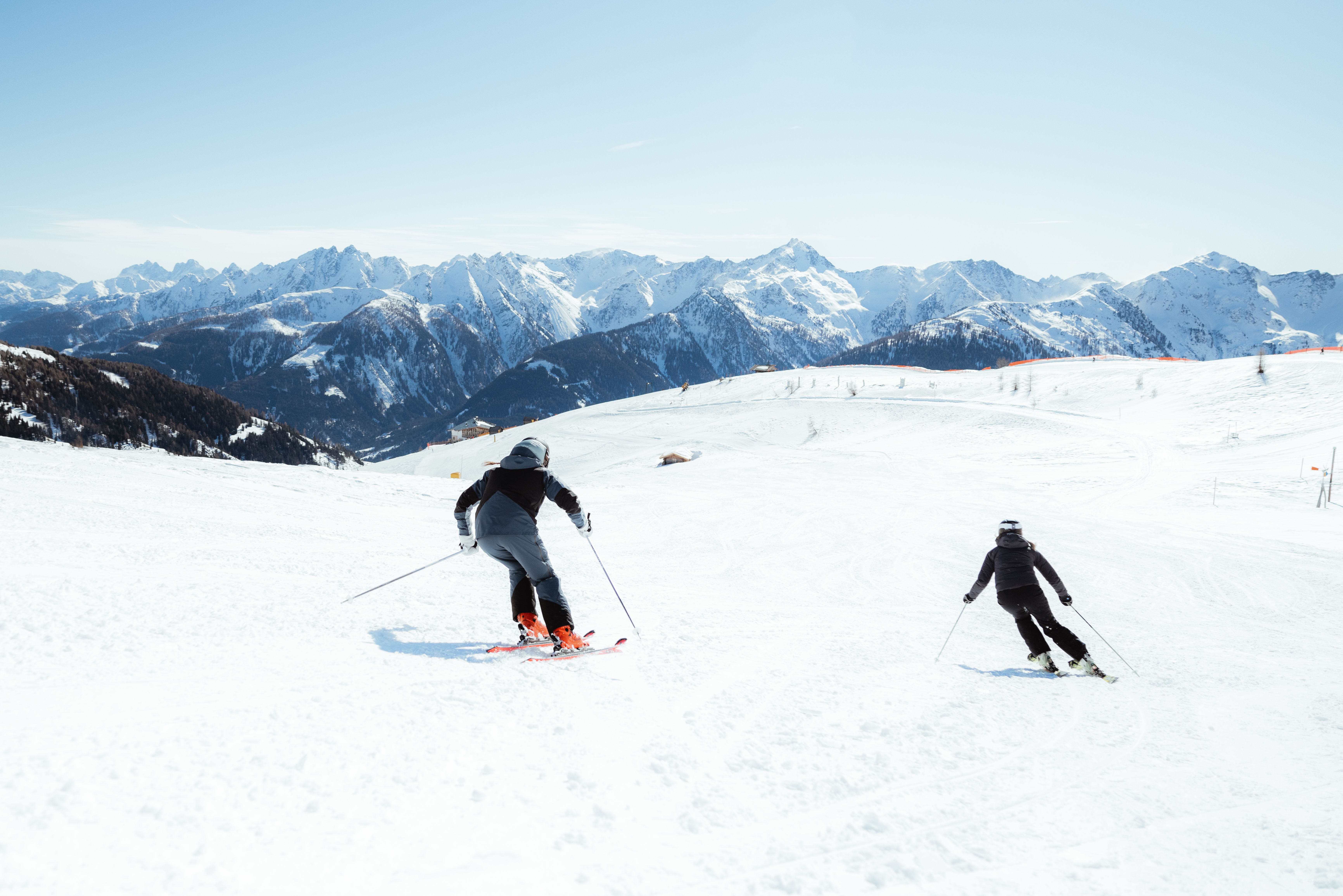 Skifahren am Golzentipp in Obertilliach, Osttirol. Zwei Skifahrer auf der Piste mit Bergpanorama.