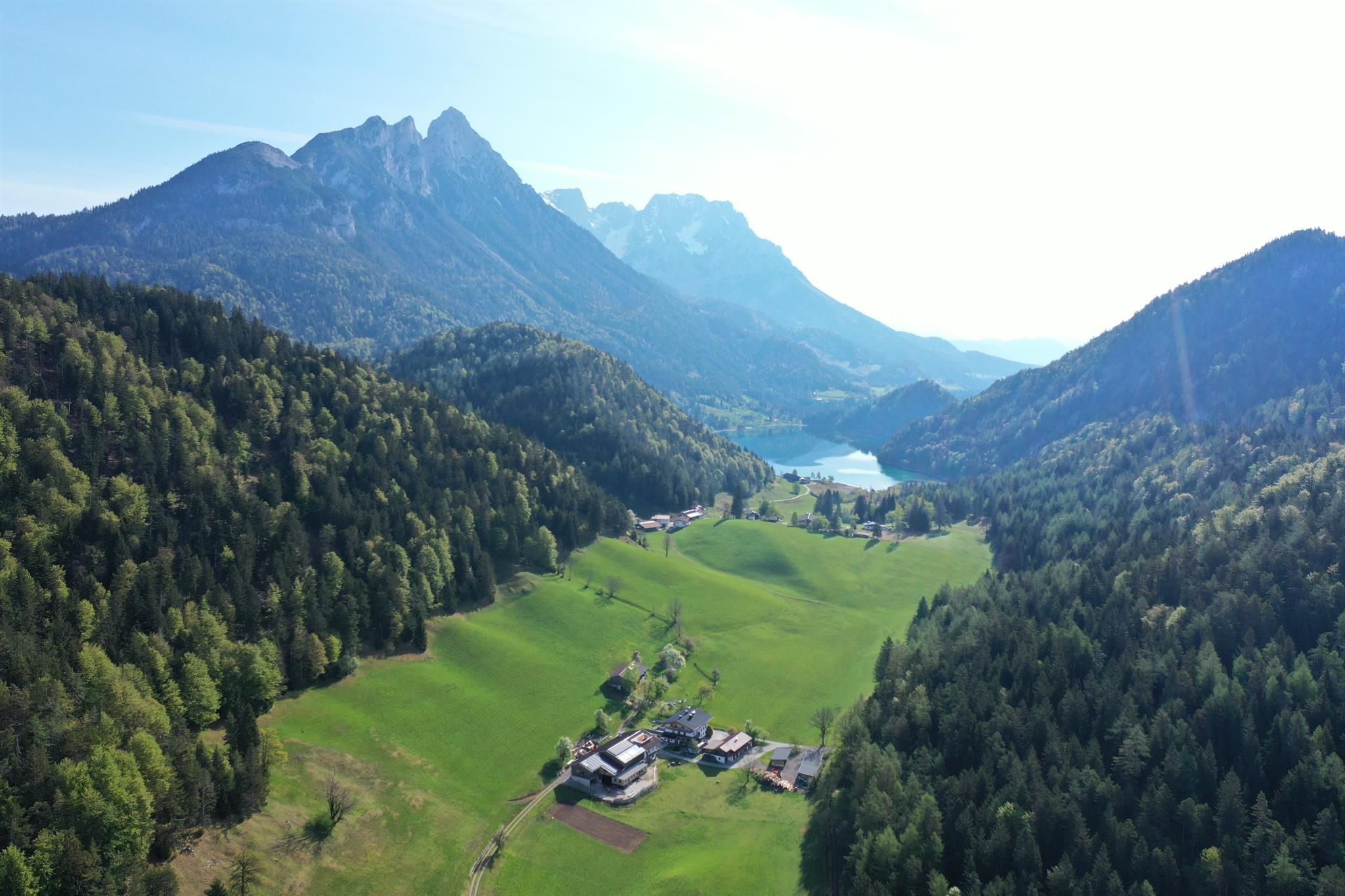 Eine malerische Landschaft mit grünen Wiesen, Bergen und einem klaren See. Die natürliche Schönheit der Umgebung strahlt Ruhe und Frieden aus.