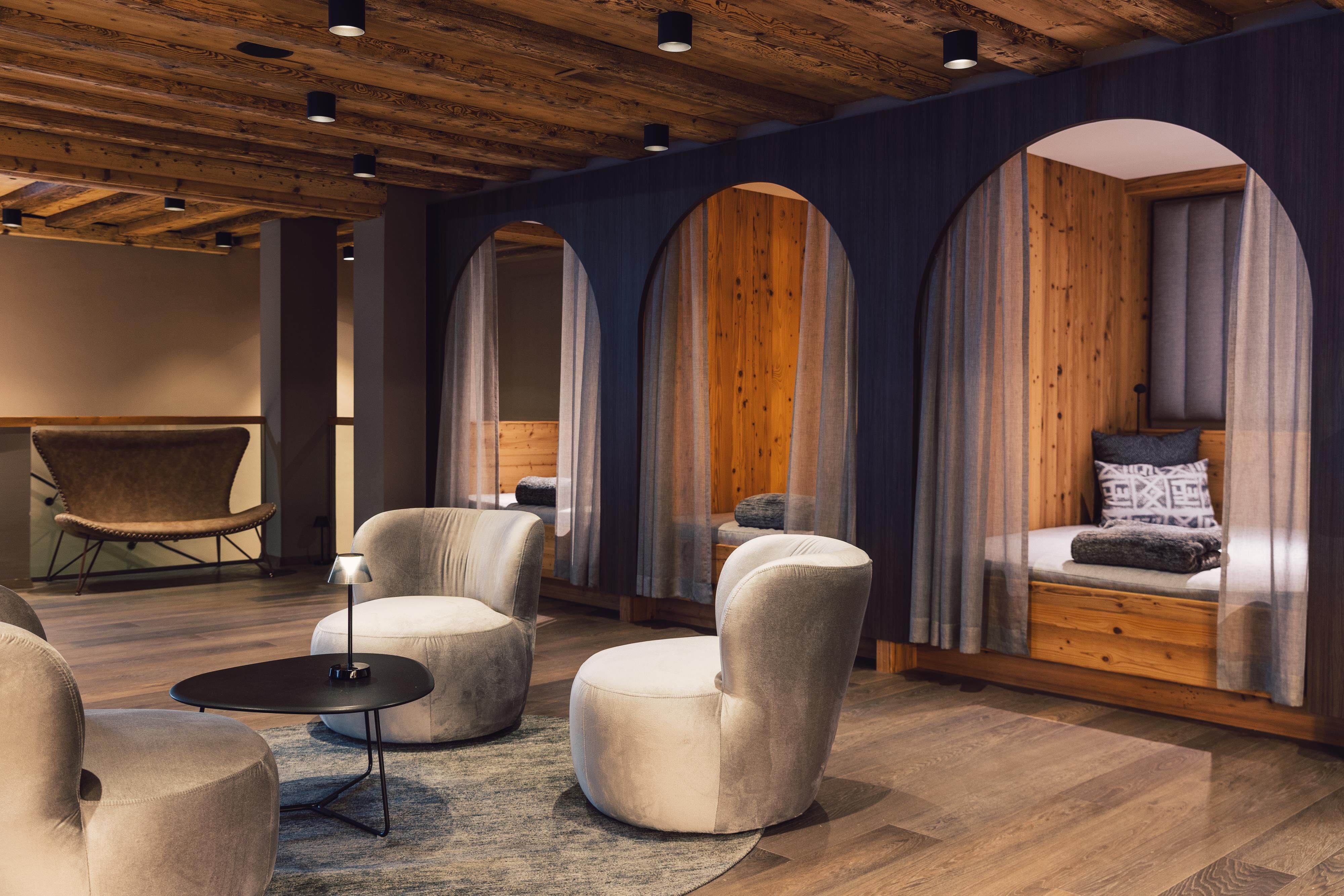Ein modernes Wohnambiente mit bequemen Stühlen und Holzdetails. Drei Nischen mit Betten bieten gemütliche Rückzugsorte.