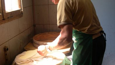 Opa bei der Käseproduktion