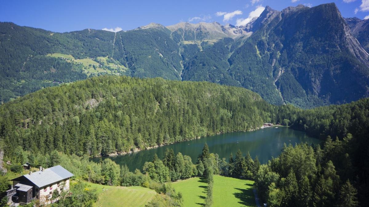 Wer Oetz besucht, kommt um den Piburger See nicht herum, wiewohl sich der mit 23 Grad wärmste Gebirgssee Tirols hinter einer Anhöhe verbirgt. Wanderer schätzen den Gegensatz zwischen den Achstürzen der Ötztaler Ache und der Beschaulichkeit des Sees, Gourmets die Seeforellen., © Ötztal Tourismus/Elias Holzknecht