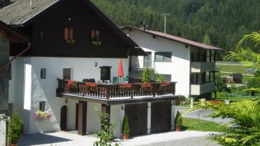 Ferienhaus Rückseite mit Terrasse und Parkplätze