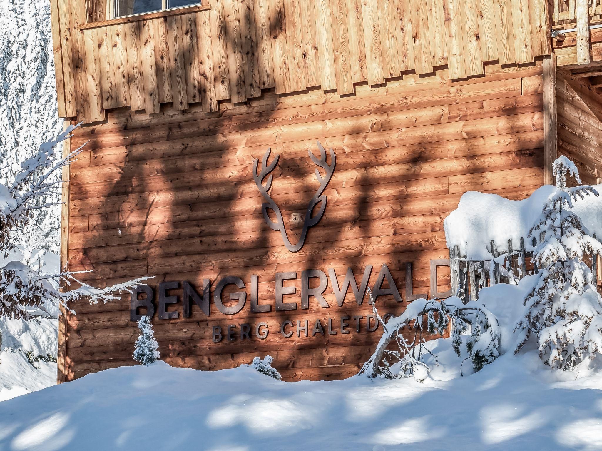Ein Chalet im Schnee mit einer Beschilderung. Der Schriftzug "Benglerwald" und ein stilisierter Hirschkopf sind deutlich sichtbar.