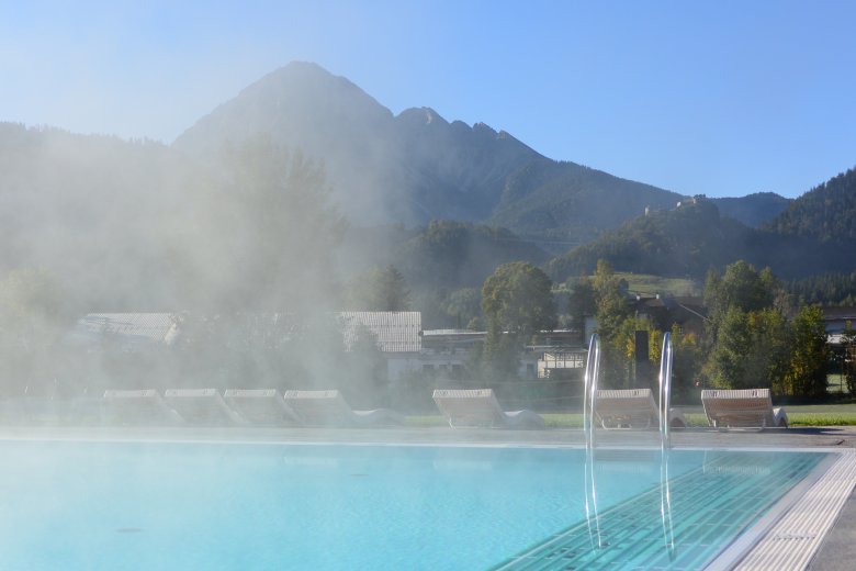 Gemütliches Planschen im beheizten Freiluft-Solebecken der Alpentherme Ehrenberg. Mit der Aktiv Card Reutte baden Urlaubsgäste hier zwei Stunden kostenlos.