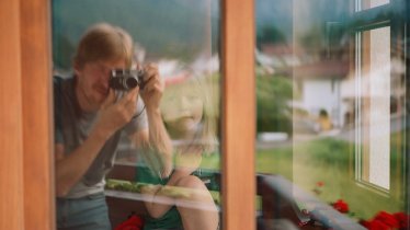 Spiegelbilder: Fanny richtet sich im Erker hinter einem dicken Vorhang ihr eigenes Reich ein. Hier verteilt sie ihr Spielzeug, ihre Kamera, die Stifte und Malbücher. „Hier mit im Bild und sonst fast immer an meiner Seite, meine Leica. Das tägliche Festhalten des Alltags hat mir auch während des Einerleis der Pandemie Halt gegeben“, sagt Zapatka.