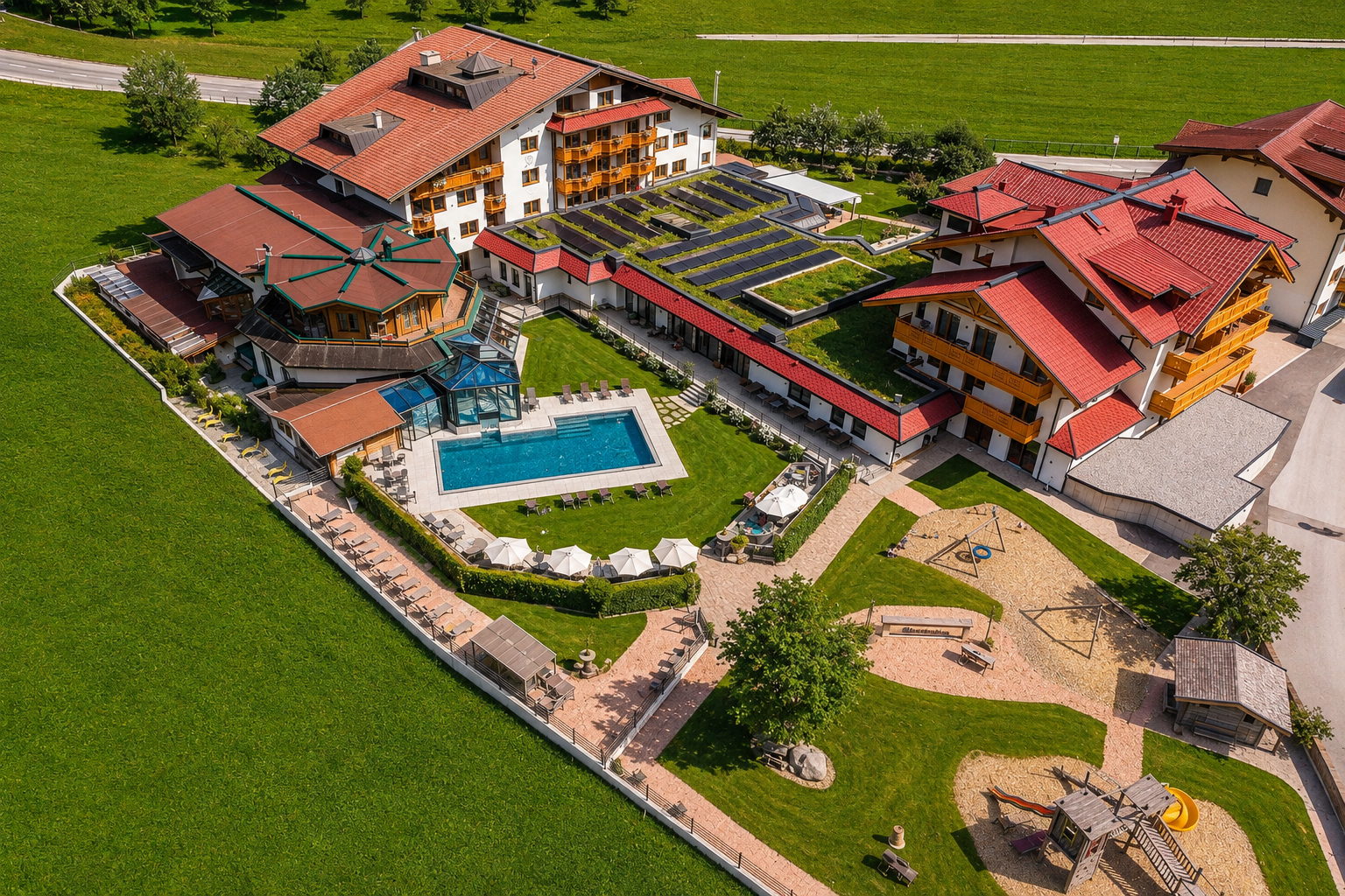 Ein farbenfrohes Hotel mit mehreren Gebäuden, Pools und einem großen Garten. Der Außenbereich bietet Spielplätze und gemütliche Sitzgelegenheiten.