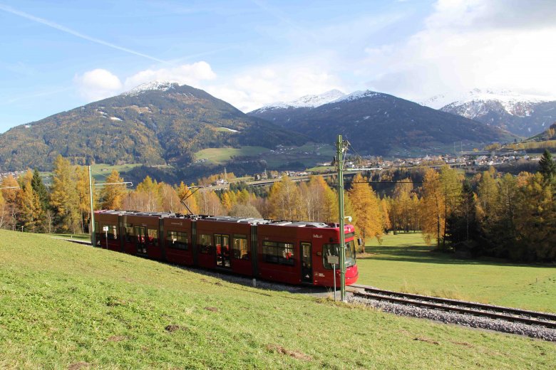 Idyllische Fahrt von Innsbruck nach Fulpmes im Stubaital: Hier tuckert die Straßenbahn über die Telfer Wiesen. Im Hintergrund sieht man den schneebedeckten Patscherkofel. (Foto: Haisjackl)