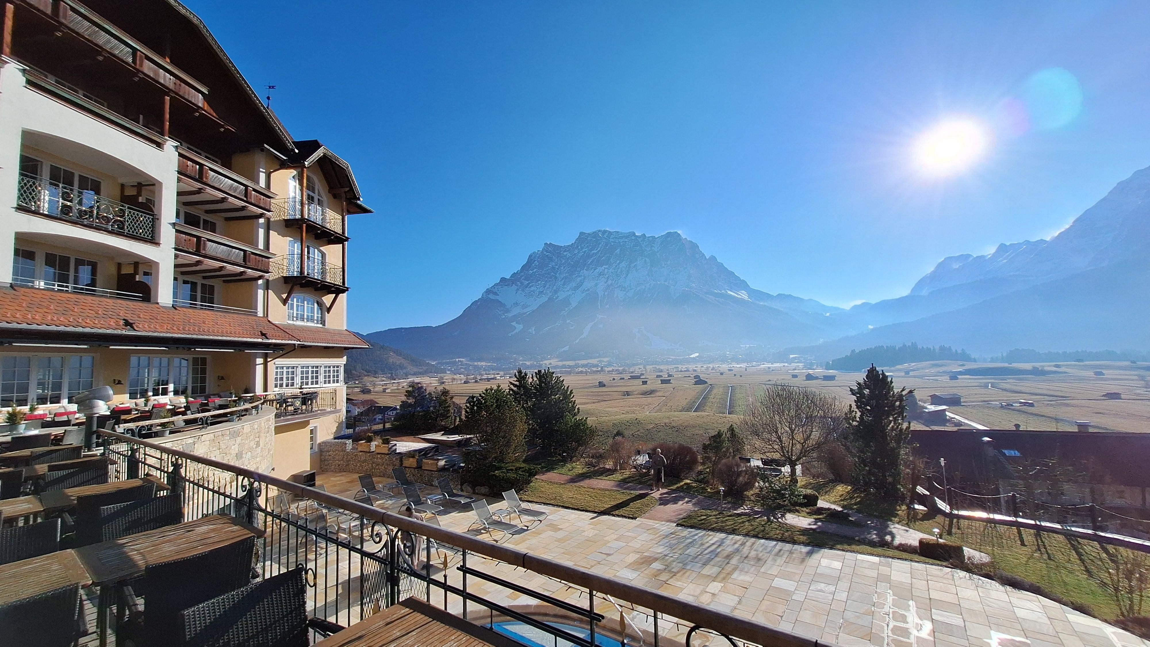 Ein schönes Hotel mit Blick auf die Berge und die klare, blaue Himmel. Die Landschaft ist grün und einladend.