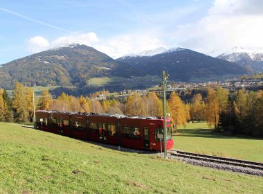 Idyllische Fahrt von Innsbruck nach Fulpmes im Stubaital: Hier tuckert die Straßenbahn über die Telfer Wiesen. Im Hintergrund sieht man den schneebedeckten Patscherkofel. (Foto: Haisjackl)