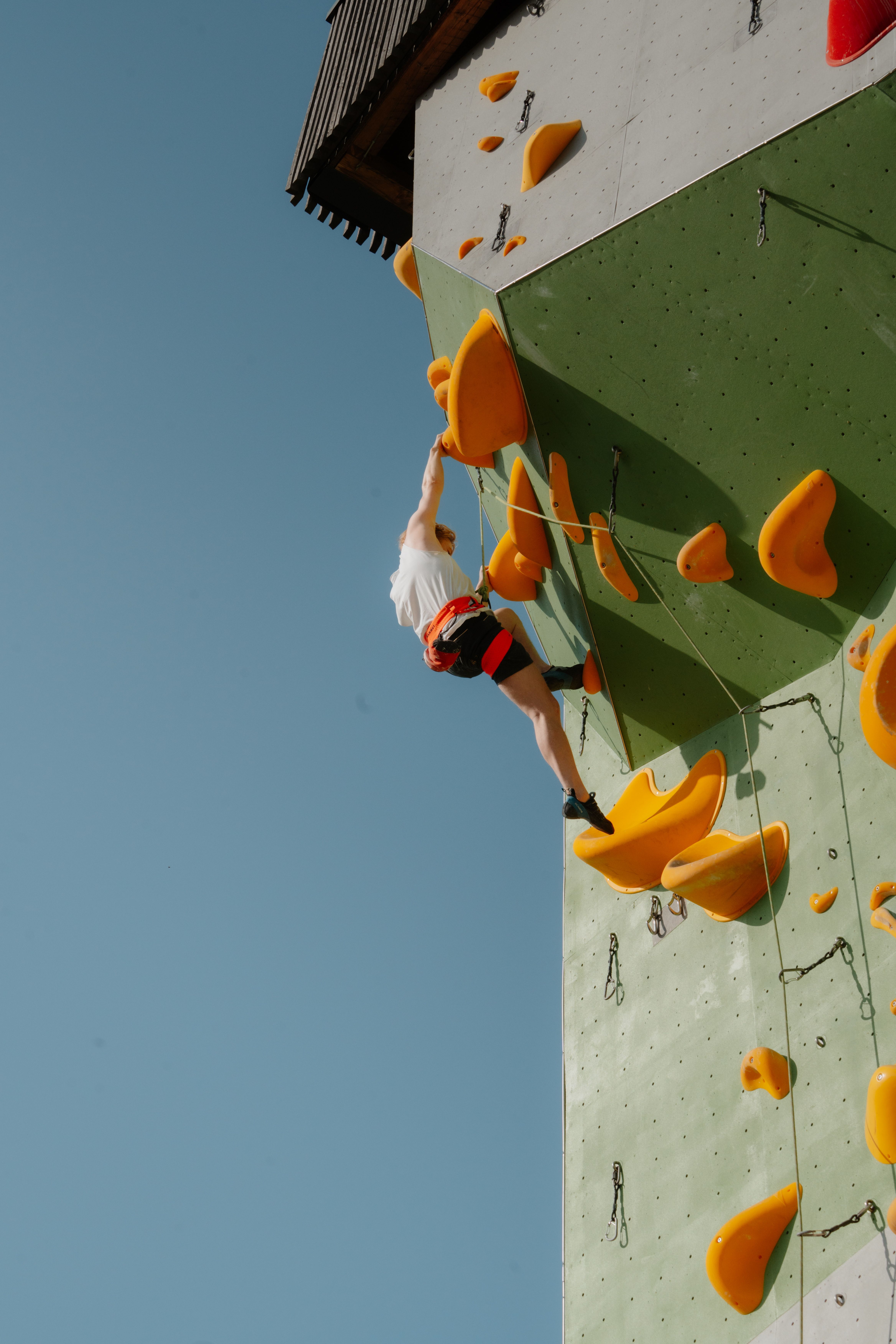 Eine Kletterwand auf der eine Frau klettert