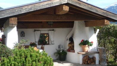 Gartenhaus mit Grillstelle im Sommer