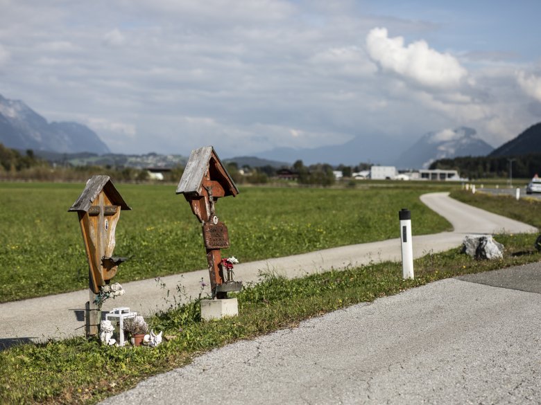 B171 bei Radfeld: Zwei Kreuze gedenken zweier Opfer von Verkehrsunf&auml;llen aus den Jahren 2001 und 2017. Statt Gem&auml;lden finden sich auf modernen Marterln oft Fotos &ndash; und in diesem Fall ein Goethe-Zitat.