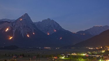 Im Talkessel von Ehrwald bietet sich ein freier Blick auf die vielen Sonnwendfeuer in der Tiroler Zugspitz Arena, © Albin Niederstrasser