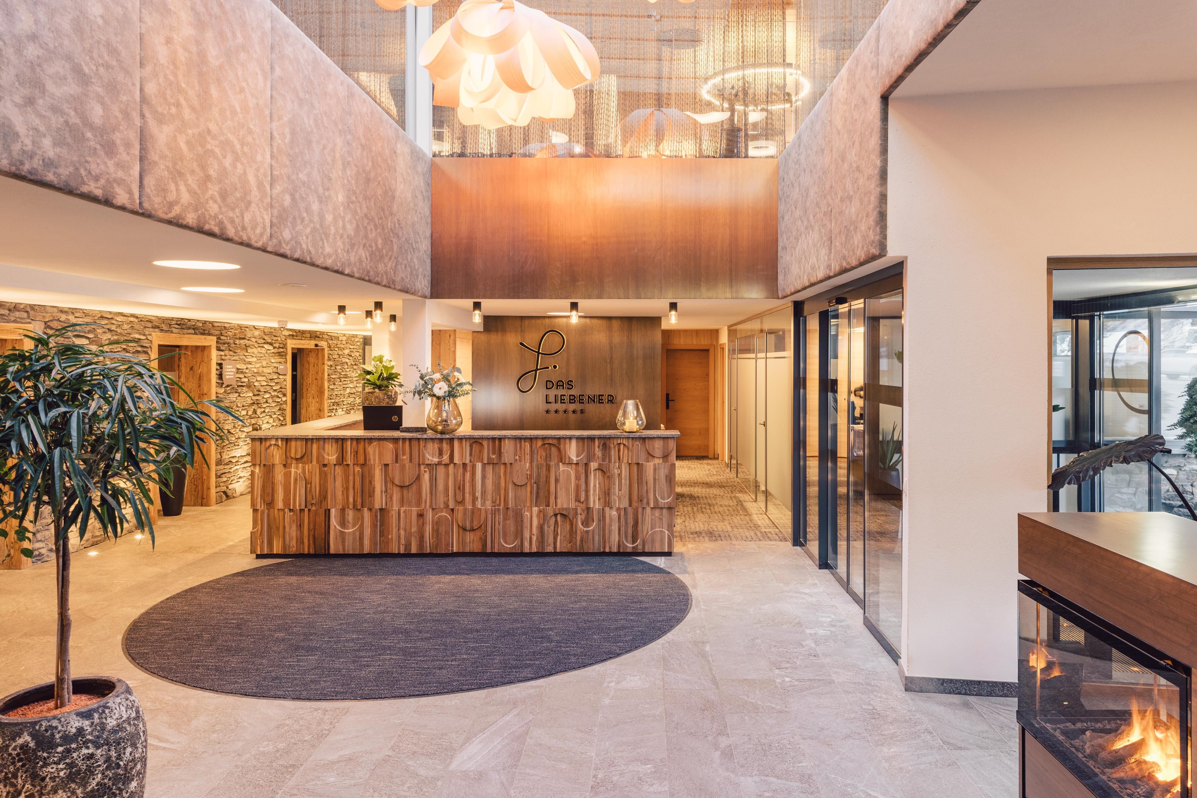 Eine elegante Hotellobby mit einem modernen Empfangstresen aus Holz. Große Fenster und eine gemütliche Atmosphäre schaffen einladenden Komfort.
