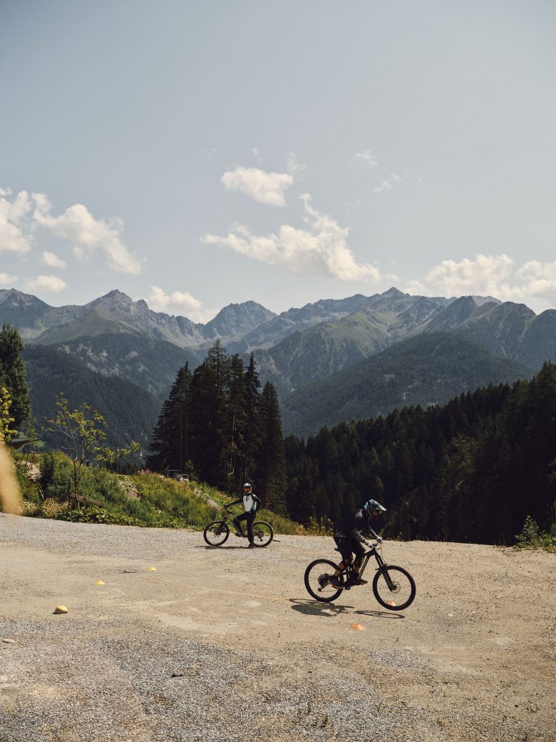Die ersten Schritte beziehungsweise Rollversuche macht unser Autor auf einem Schotterplatz in der Nähe des Bikeparks. Im Hintergrund die Ötztaler Alpen.