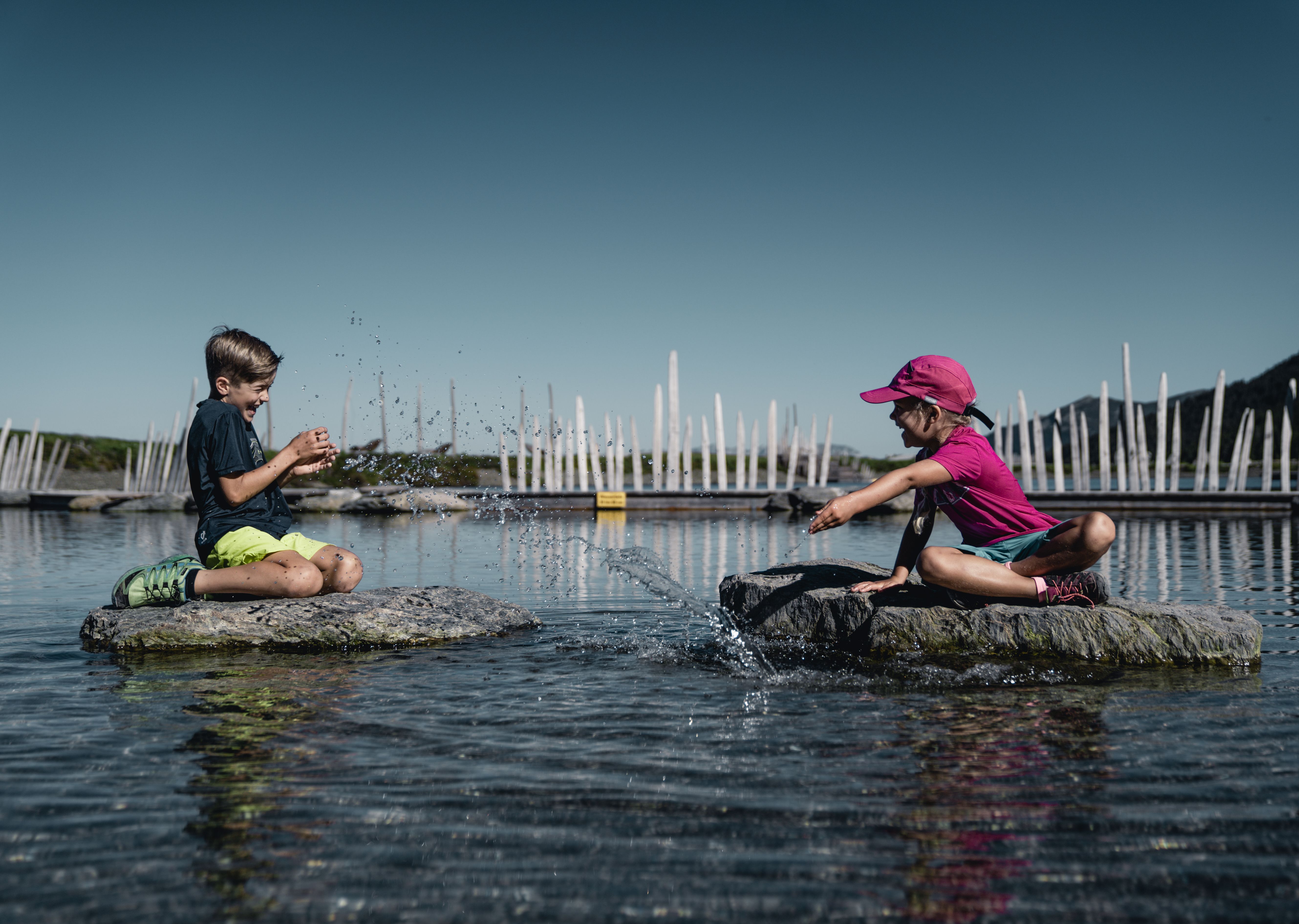Fichtensee Zillertal, Kinder spielen auf Floßen im See