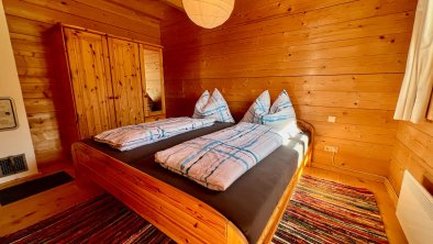 Schlafzimmer mit Doppelbett, © im-web.de/ Berghuetten Moser GmbH