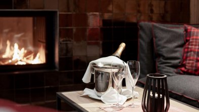 Cosy open fire place with a bottle of champagne  I