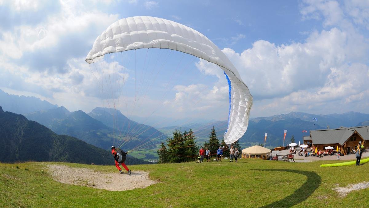 Einmal den wunderschönen Kaiserwinkl aus der Vogelperspektive erleben – über dem Talkessel von Kössen ist das kein Problem. Hier tummeln sich im Sommer die Gleitschirmflieger. Am Flugberg Unterberghorn werden für Anfänger Tandemflüge angeboten., © Tirol Werbung/Josef Mallaun