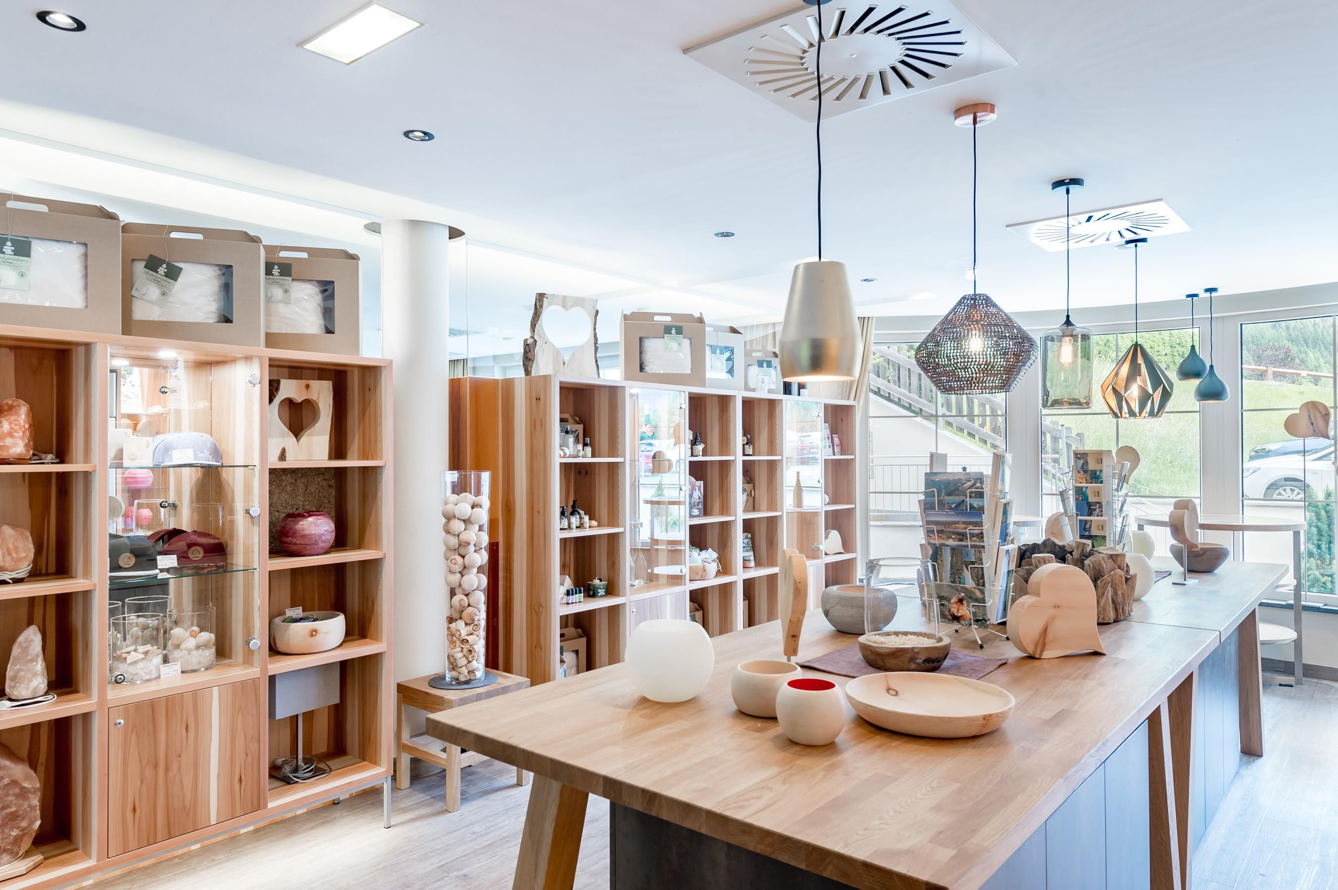 Ein modernes Geschäft mit Holzregalen und dekorativen Gegenständen. Die Beleuchtung ist freundlich und die Atmosphäre einladend.